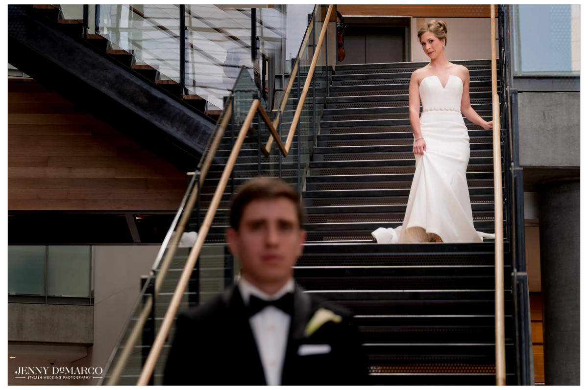 Bride walks down the stairs of the Austin Public Library for the first look.