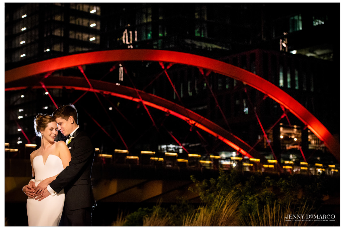 Intimate photo of the couple in front of a bridge.